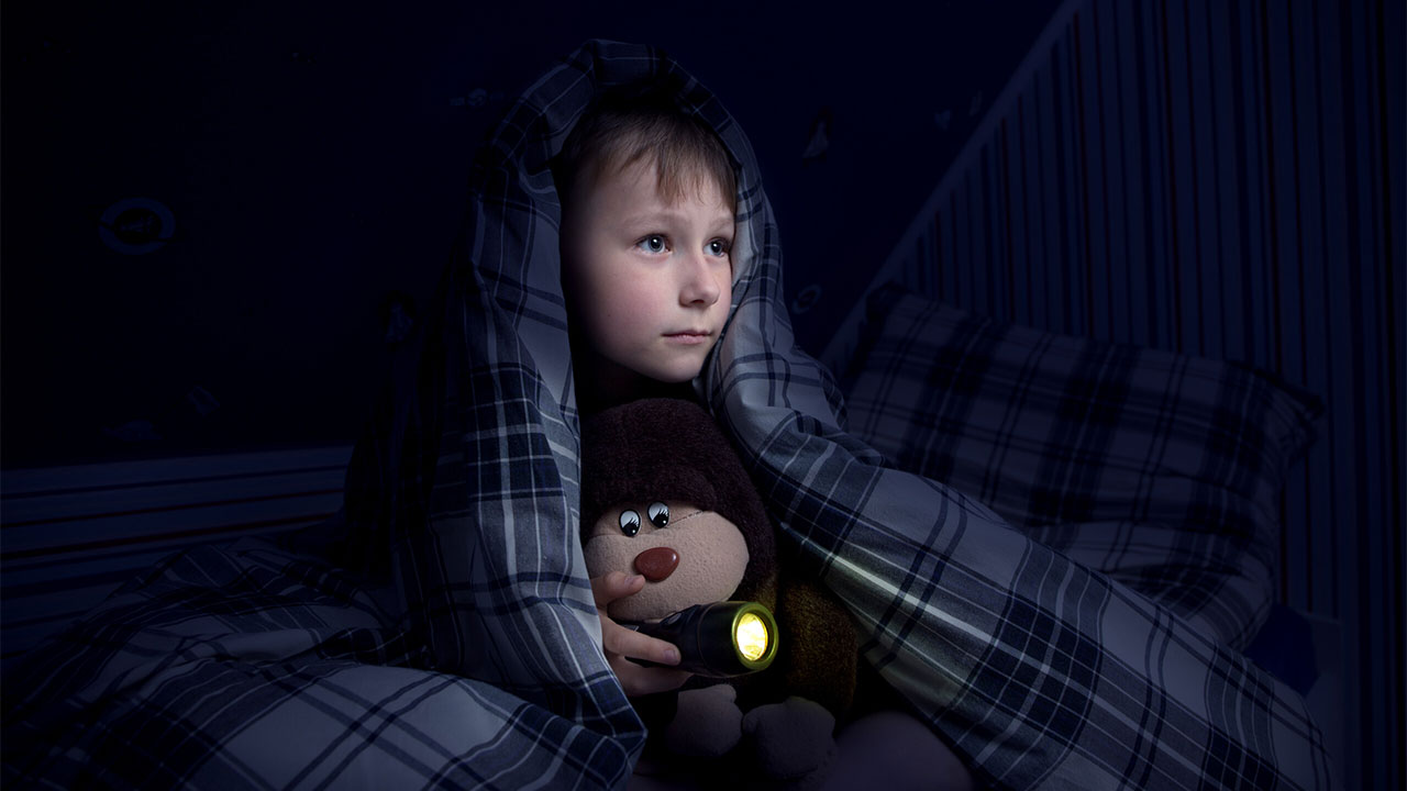 boy holding lantern in the dark